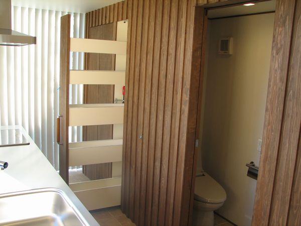 木板壁の奥は、トイレと引き出し式食器収納